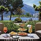 Tavolo all&#039;aperto con cibo e bevande, vista sul lago.