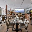 Ristorante elegante con tavoli, sedie e decorazioni floreali.